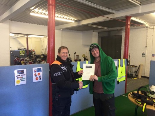 Adam being presented with his Inner Circle DAS course completion certificate after passing obtaining his full motorcycle licence