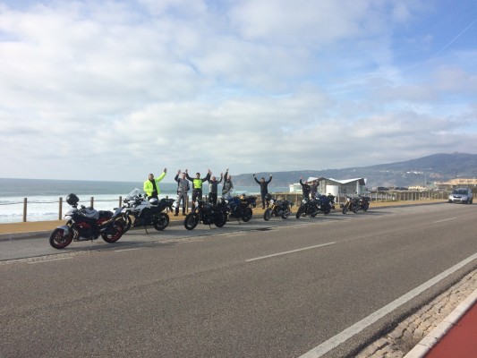 The British dealers celebrate on the ocean front at the end of their day riding the new Triumphs in Portugal